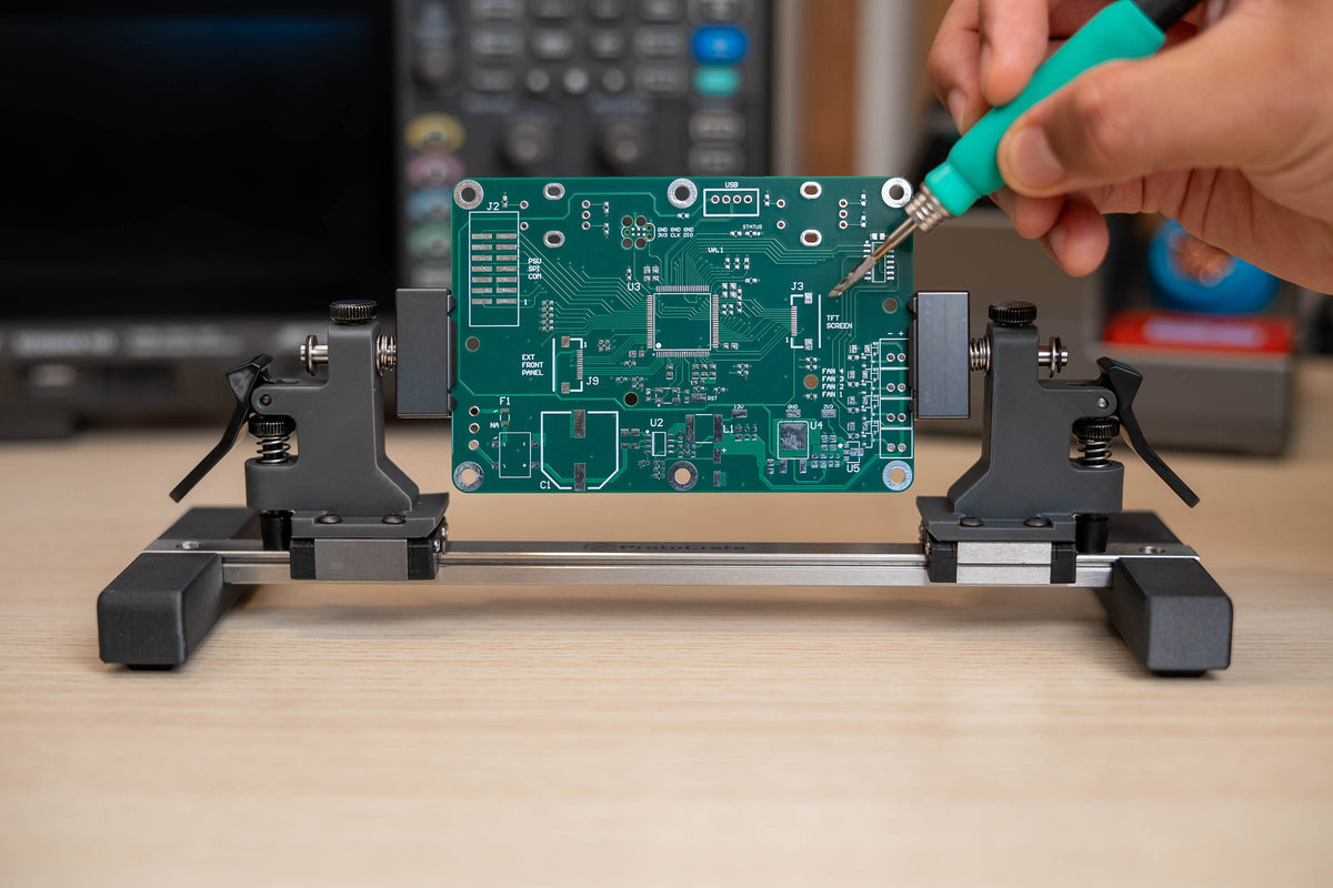 Quick Lock Pro holding a circuit board during soldering on the bench